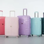Collection of modern travel suitcases in vibrant pastel and dark colors for travel and vacation.