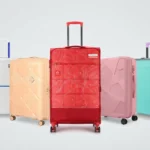 Colorful collection of modern hard-shell travel luggage and trolley suitcases lined up against a light background