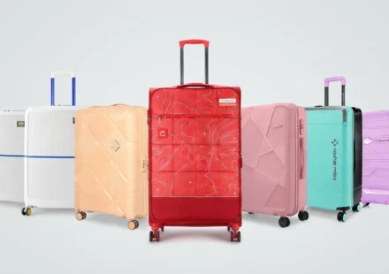Colorful collection of modern hard-shell travel luggage and trolley suitcases lined up against a light background